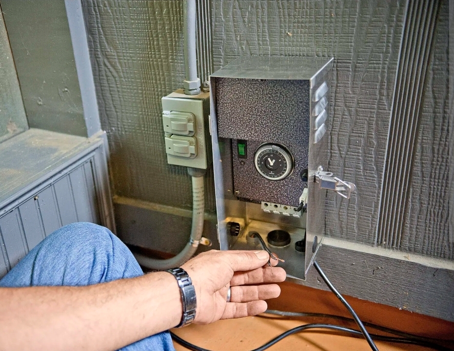 Professional electrician installing deck lighting with proper wiring and weatherproof connections