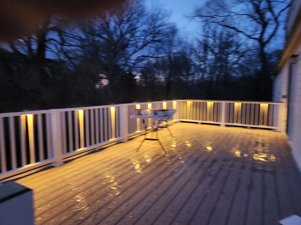 LED strip lights mounted under deck handrails creating subtle ambient lighting